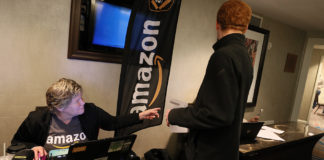 Image caption: Amazon employee Cindy Flynn assists an applicant during an Amazon job fair at the Hilton Hotel in Boston on Nov. 10, 2017. Amazon is offering on-the-spot jobs for seasonal workers as more jobs move to fulfillment of orders rather than in-store sales. (Photo by Suzanne Kreiter/The Boston Globe via Getty Images)